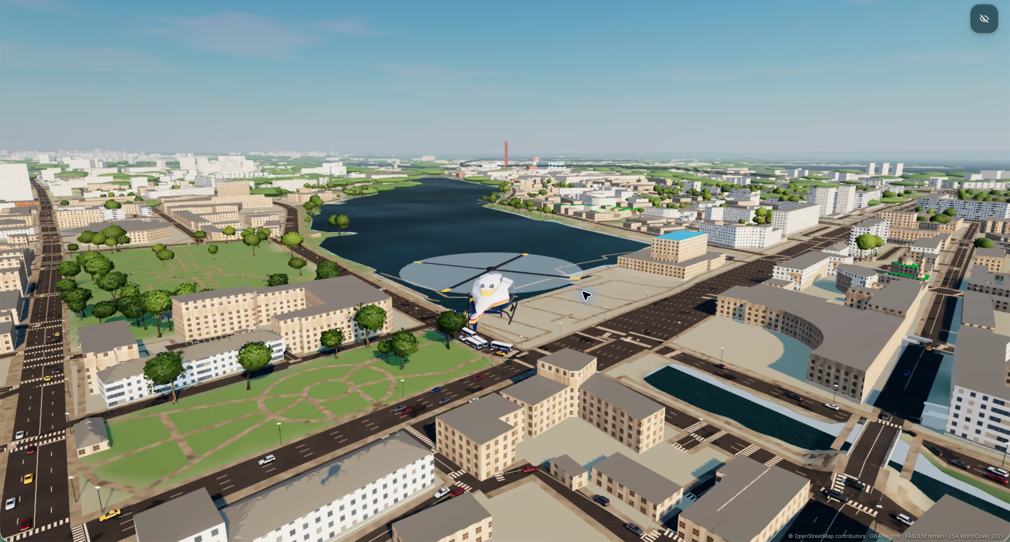 A helicopter above Slop Kazan's procedurally modeled buildings, roads and parks, with a lake stretching into the distance.